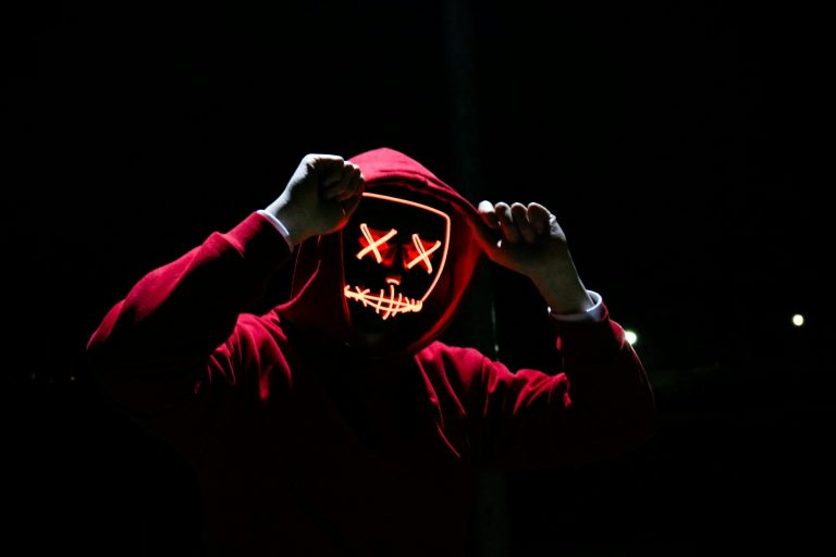 百度新站收录迅速技巧|收录规则seo排名 A spooky illuminated mask figure with a red hoodie in a dark setting, perfect for Halloween themes.